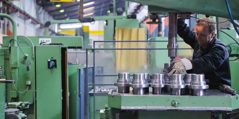 Eine Person bedient eine industrielle Fertigungasnlage.