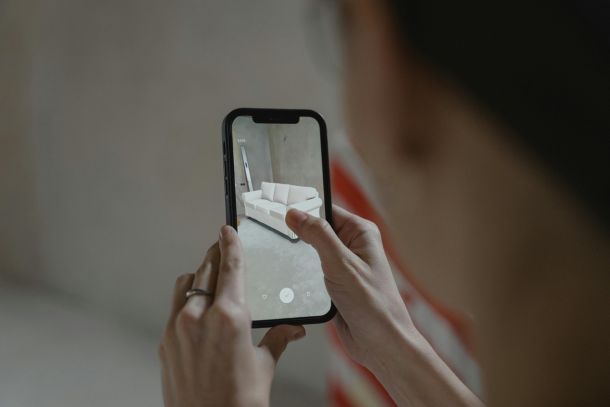 Eine Person hat ein Smartphone in der Hand und platziert auf dessen Display n in den Raum projeziertes Sofa. Bild Quelle: pexels.com